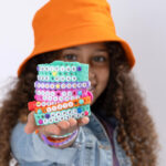 Girl holding a stack of completed bracelets on the palm of her hand
