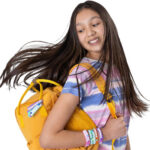 girl modeling her completed bracelets that are on her wrist and on her backpack