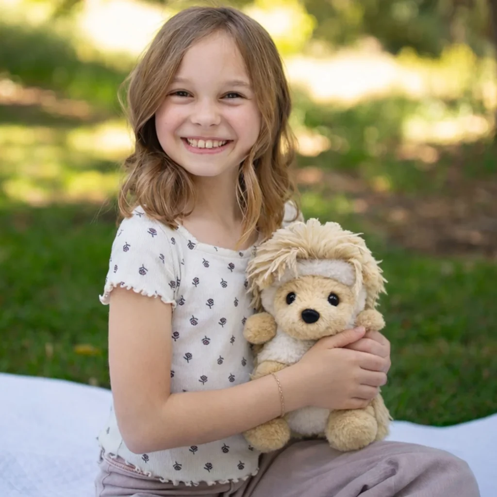 Smiling child holding the Feathers Hedgehog